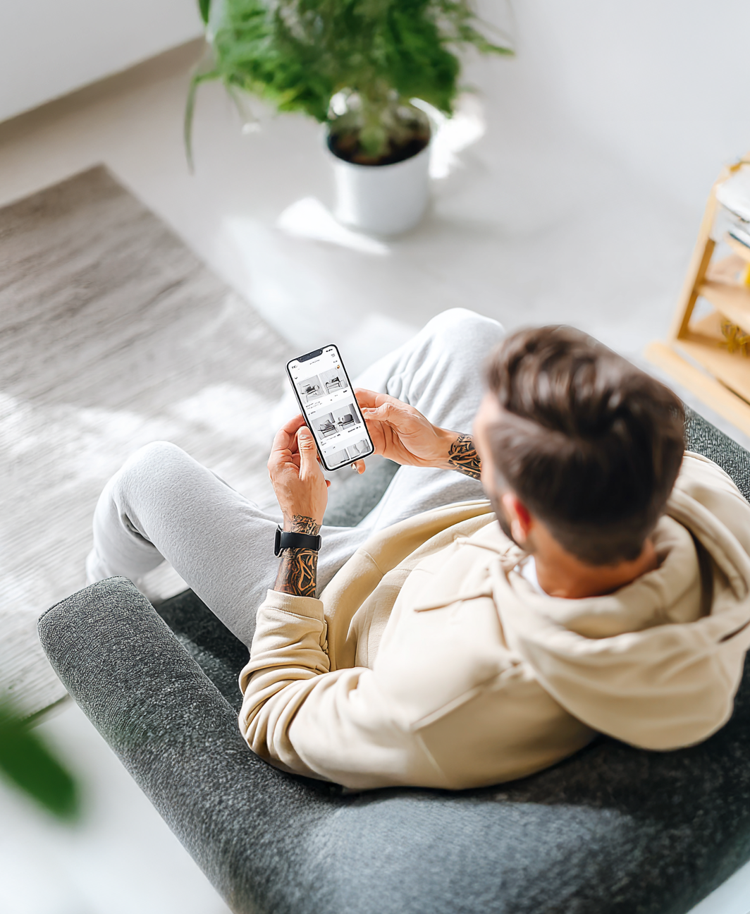 Mann mit Handy in Wohnzimmer