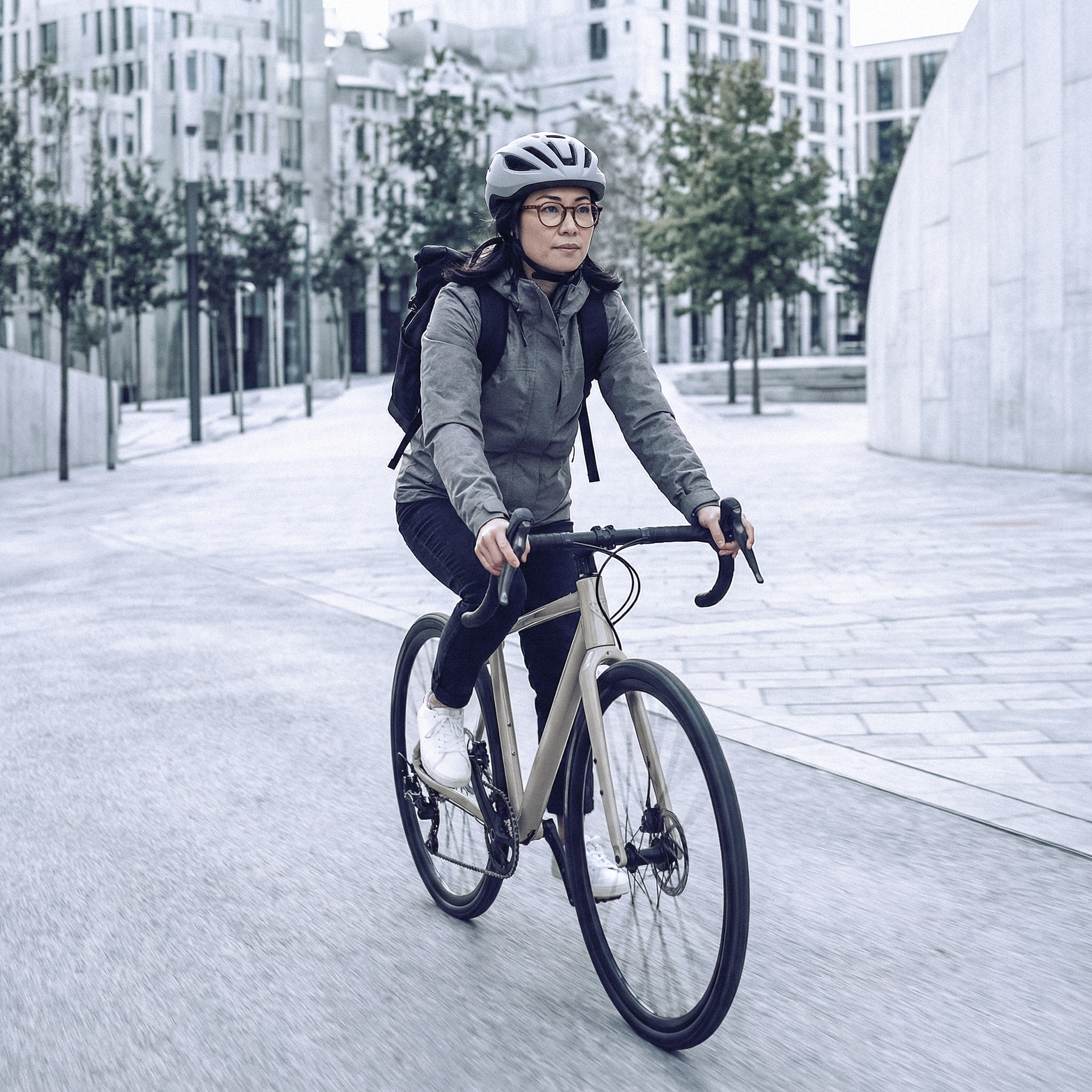 Dienstrad & Öffi-Ticket Frau mit Helm fährt Fahrrad in der Stadt auf Straße