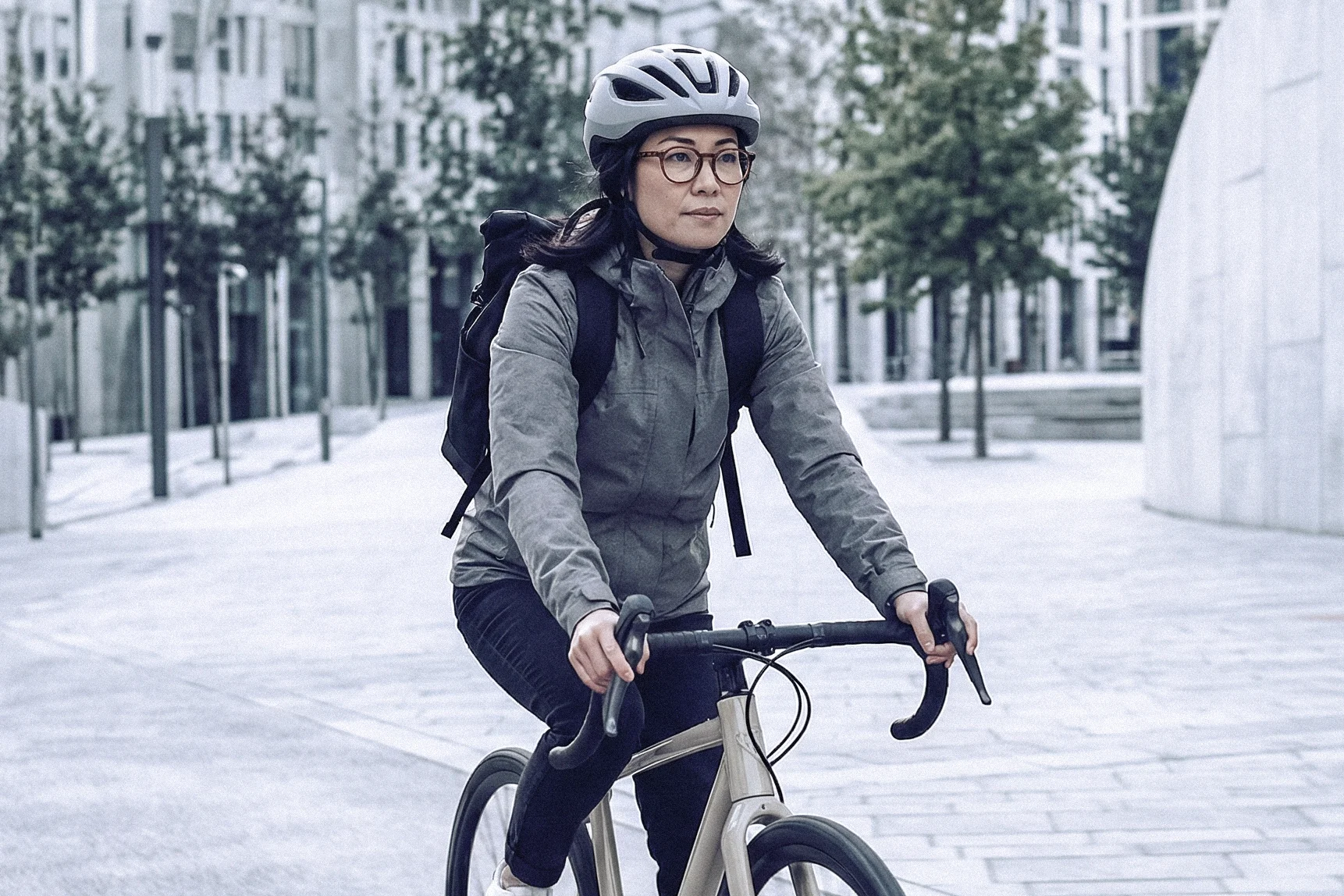 Dienstrad & Öffi-Ticket Frau mit Helm fährt Fahrrad in der Stadt auf Straße