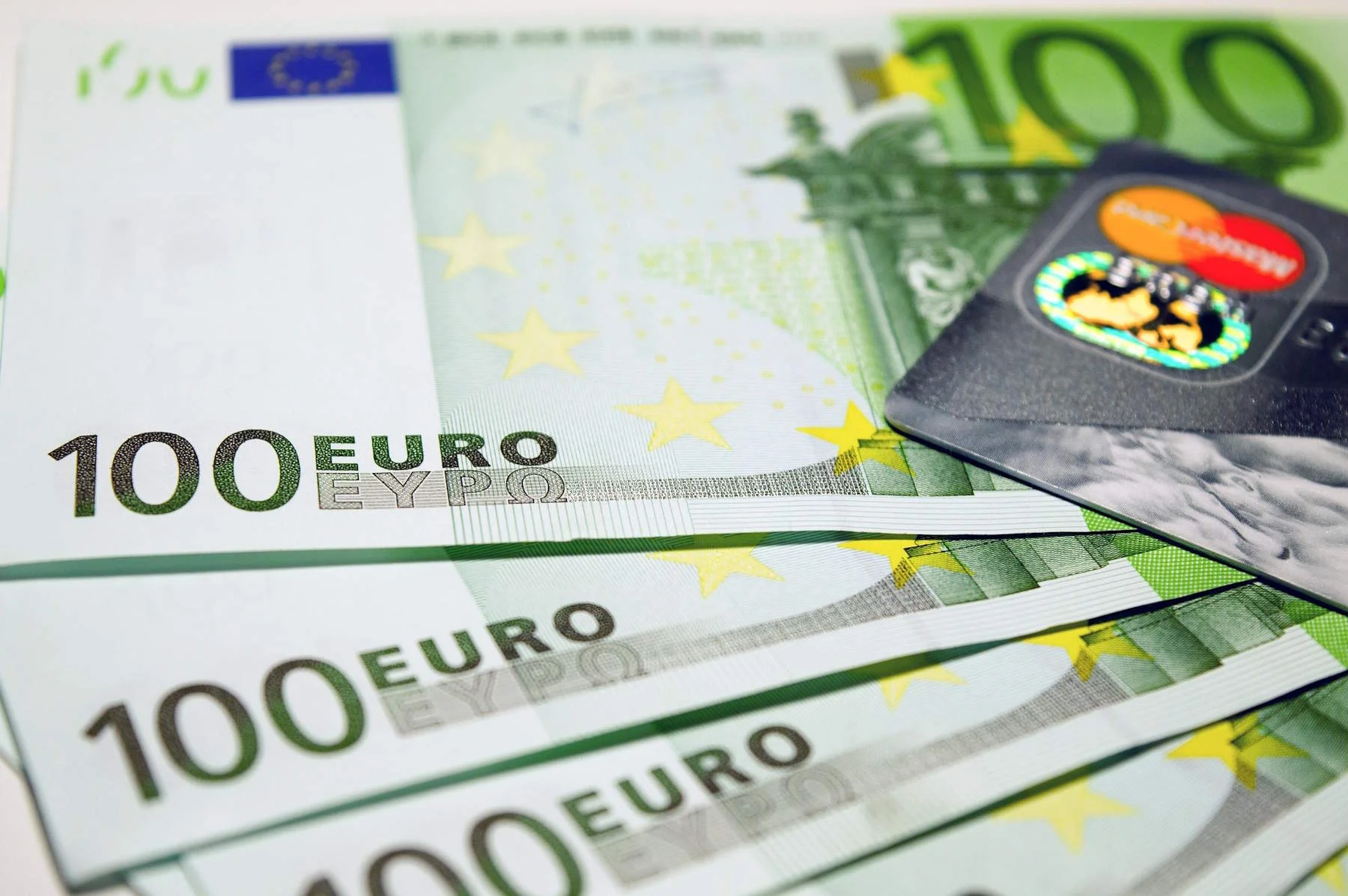 Vier Hundert-Euro-Scheine liegen aufgefäcjhert nebeneinander. Auf den Scheinen liegt ein Kreditkarte.