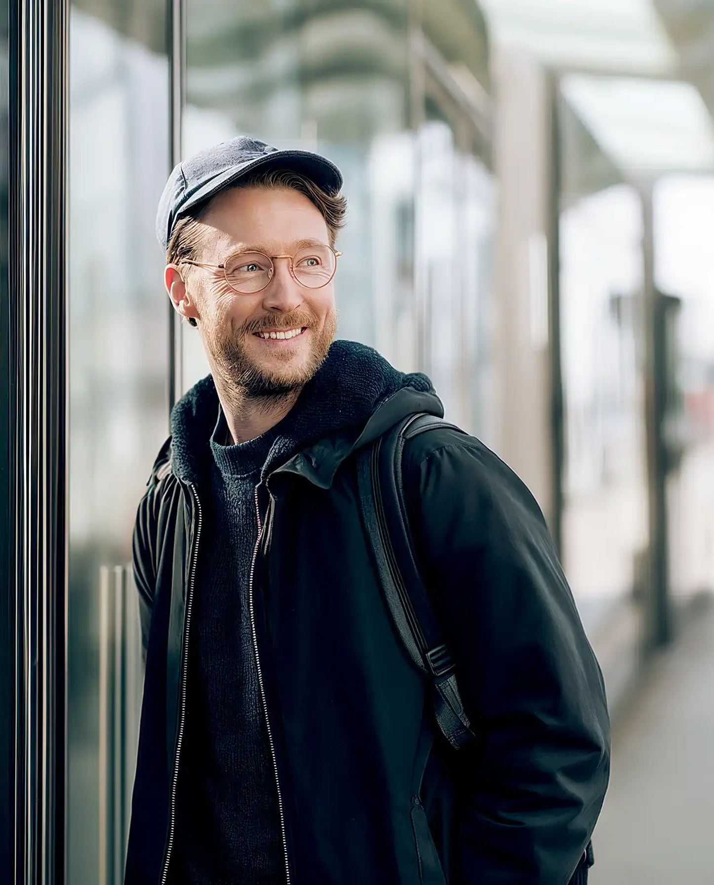 Informationen über Benefits anfordern Ein lächelnder Mann, der zur Seite schaut