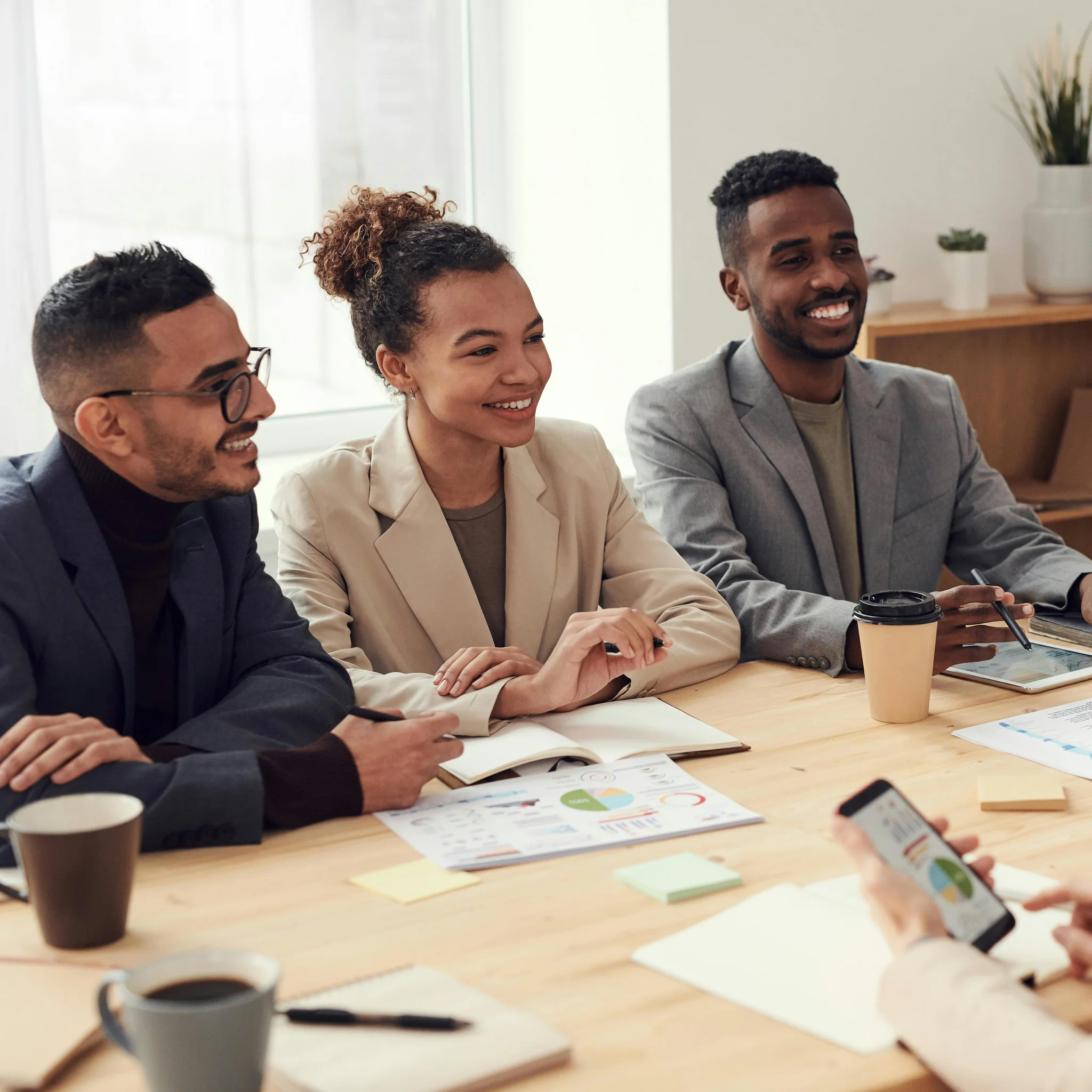 4 Mitarbeitende sitzen an Besprechungstisch