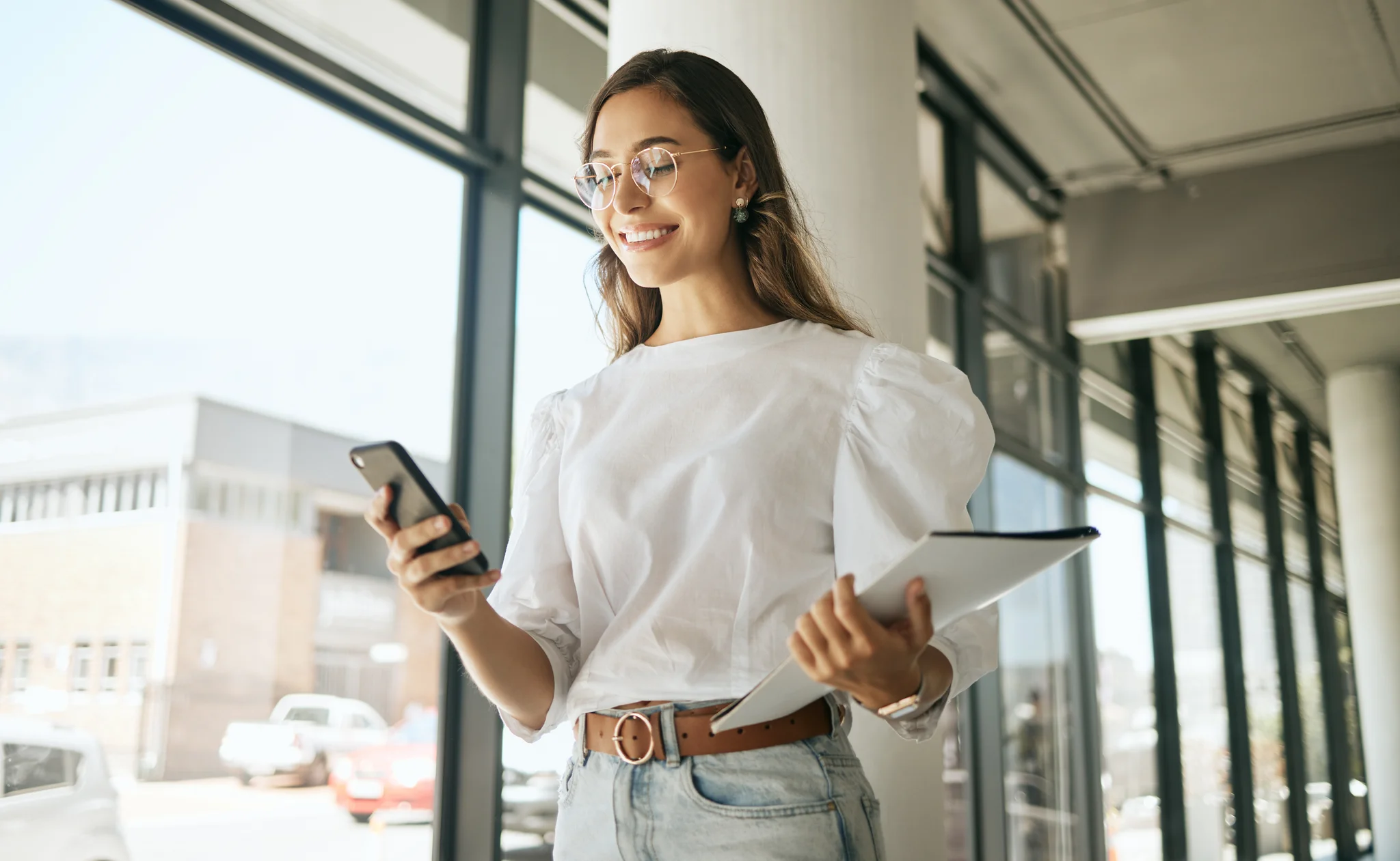 Weitere Benefits entdecken Eine Frau hält in der rechten Hand ein iPhone