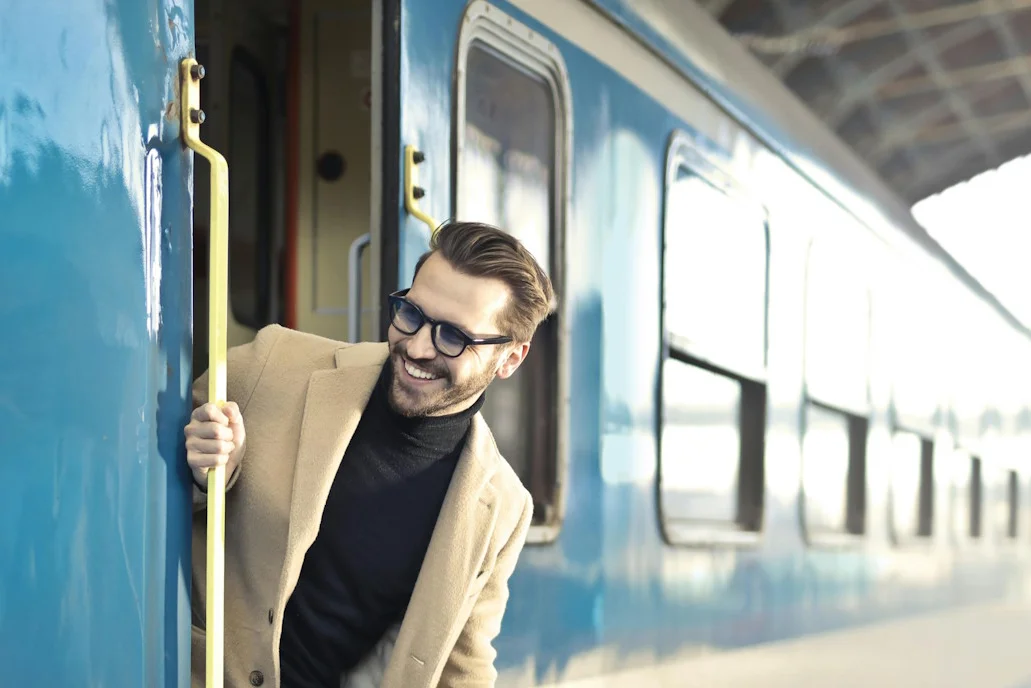 Mann lehnt sich aus stehendem Zug