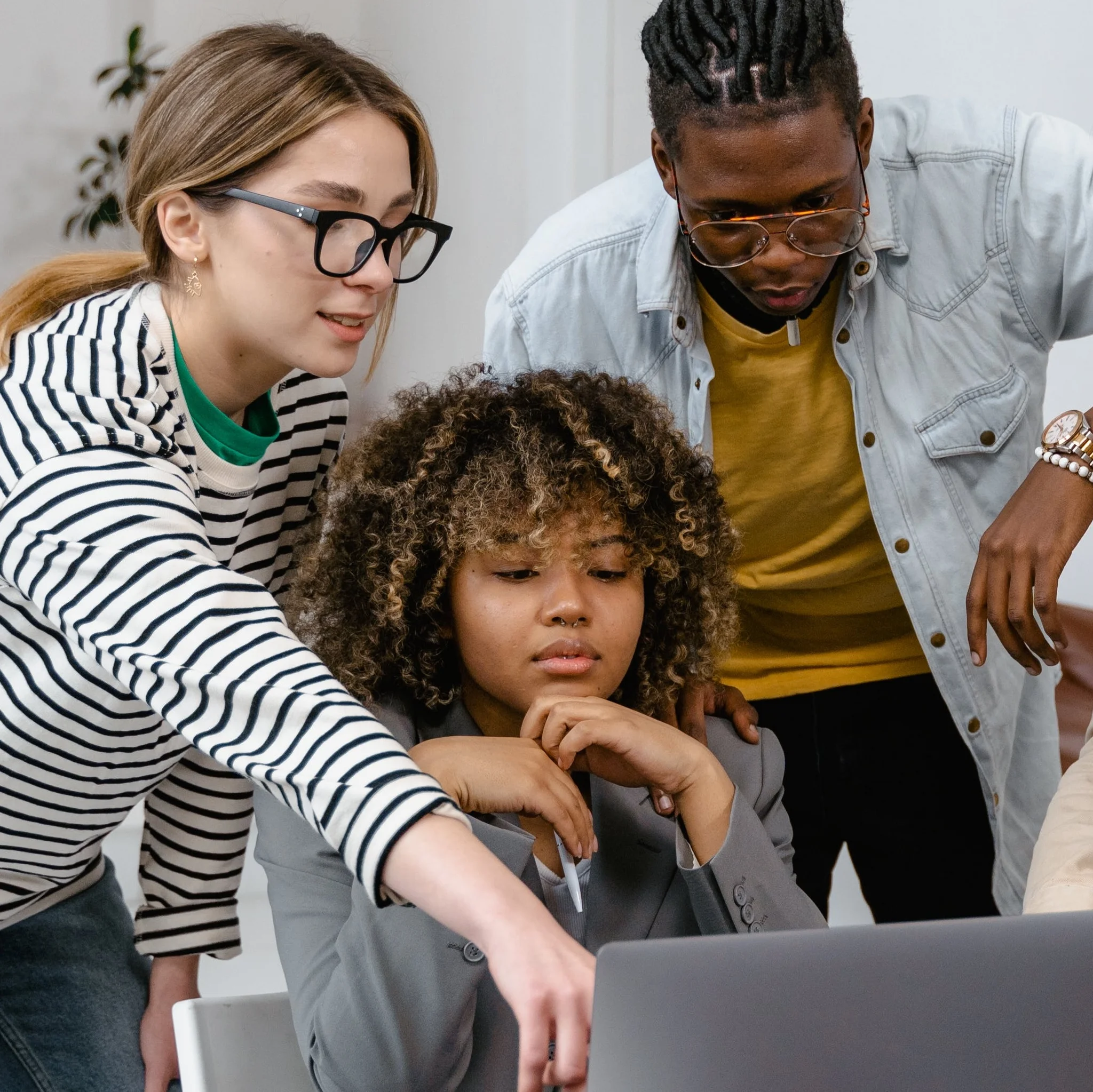 Mitarbeiter und Mitarbeiterinnen vor einem Laptop