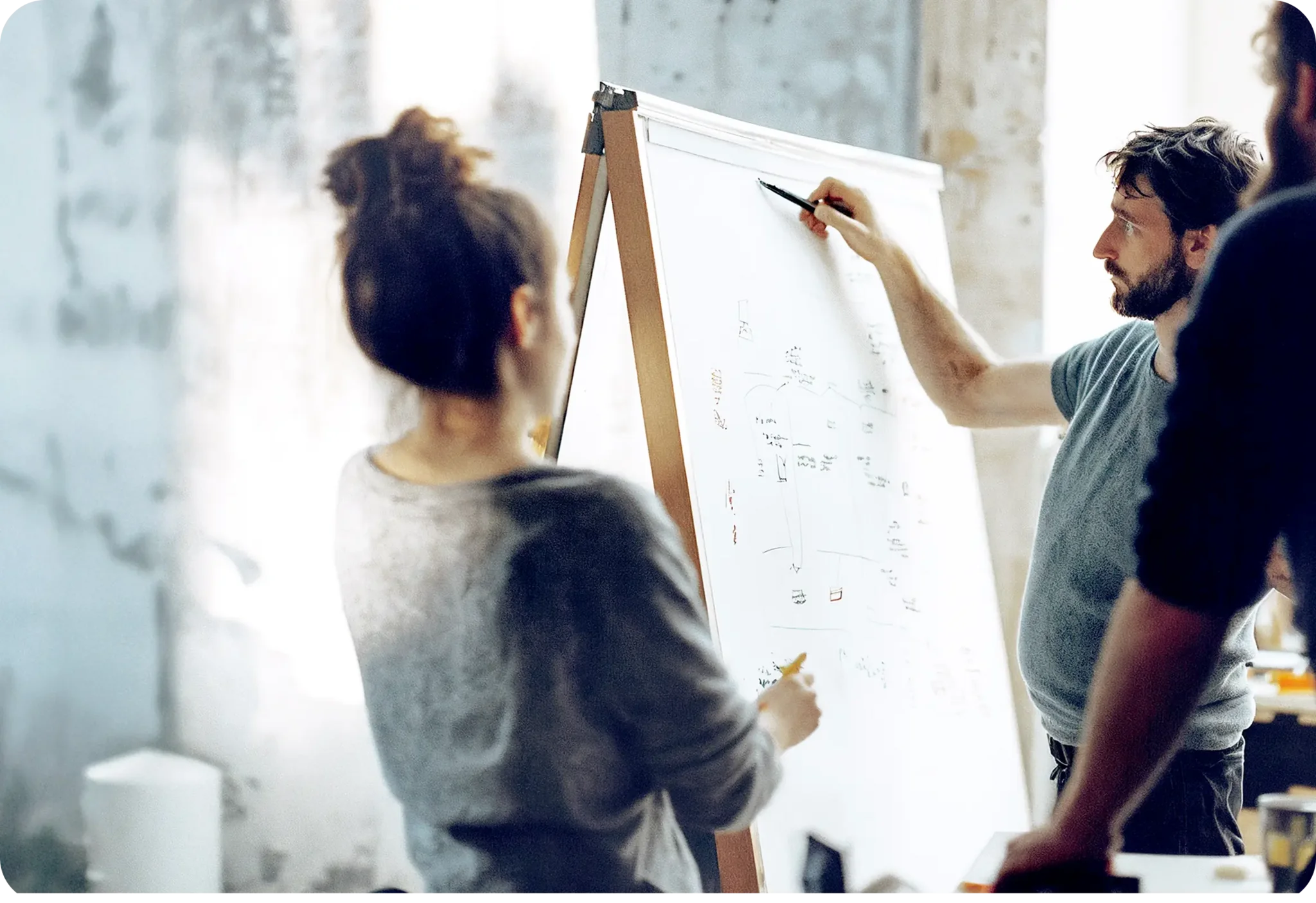 Kosten und Abwicklung Frau und Mann zeichnen auf Flipchart