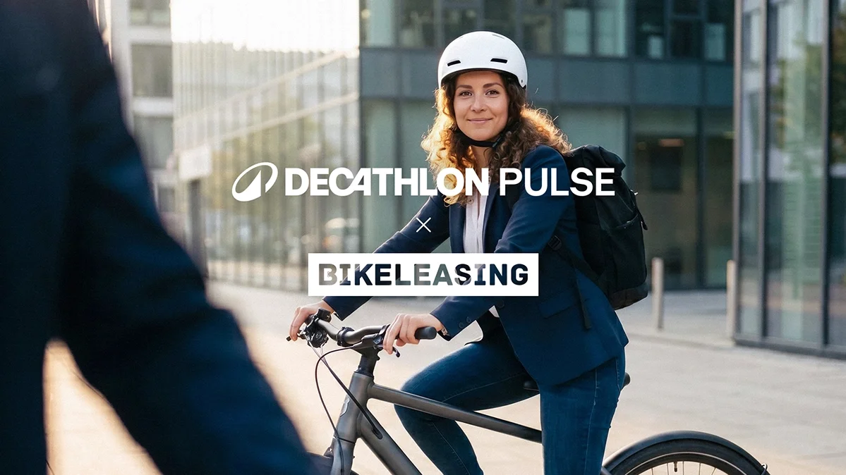 Frau mit Fahrradhelm sitzt auf einem Fahrrad vor modernen Gebäuden; darüber steht der Schriftzug „DECATHLON PULSE \times BIKELEASING“.
