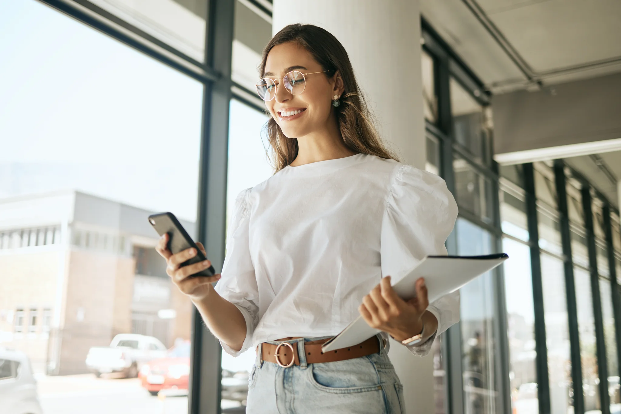 Mitarbeiterkommunikation Frau in Büro mit Handy