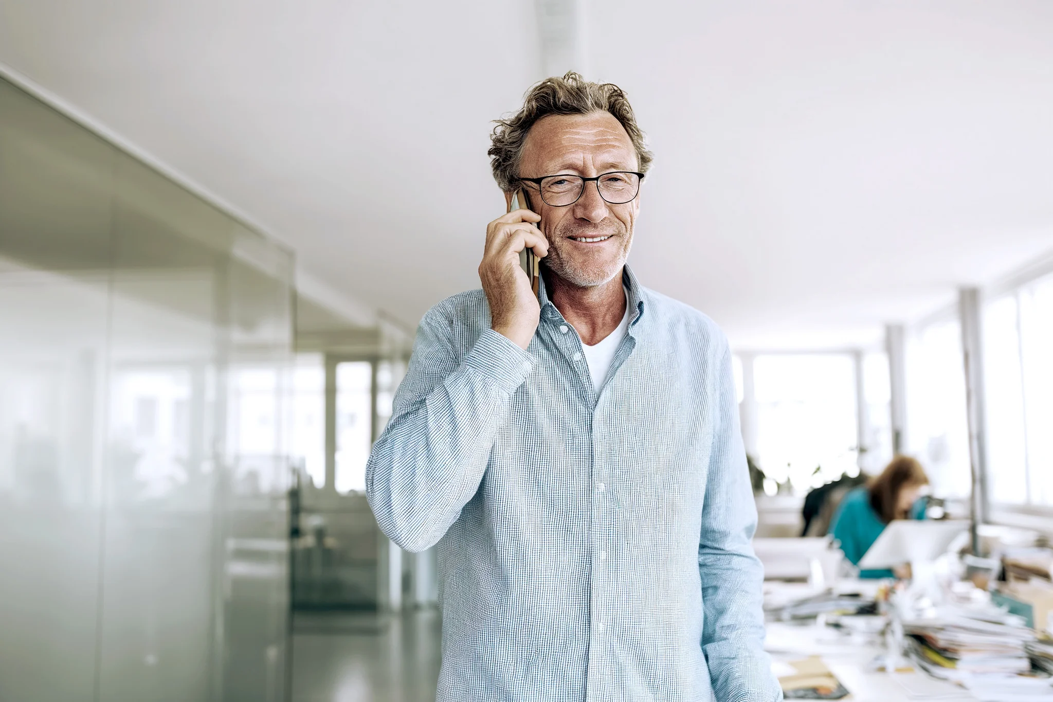 Mann steht im Büro und telefoniert.