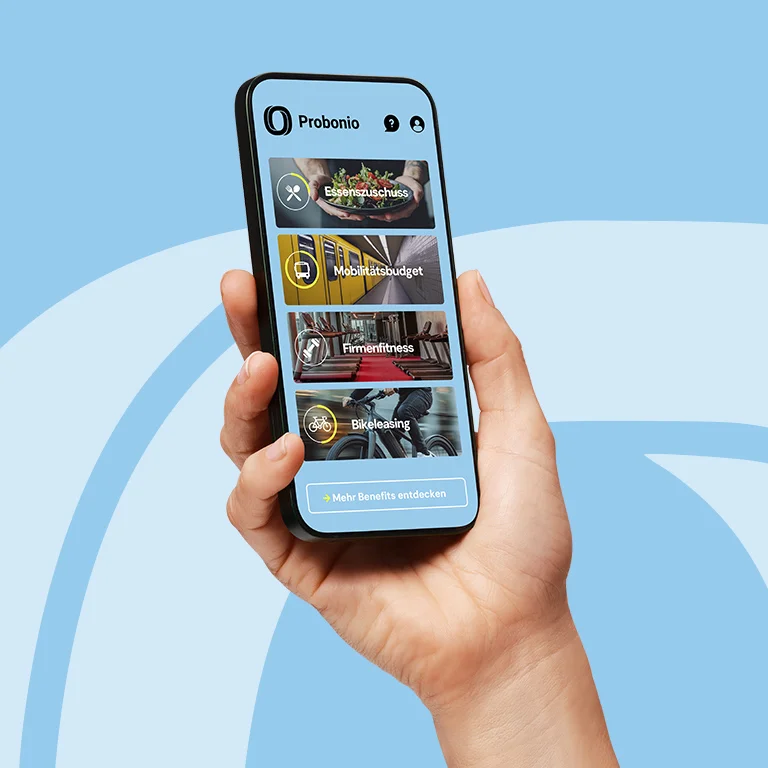 Hand hält ein Smartphone mit der Probonio-App; zu sehen sind Benefit-Kacheln wie Essenszuschuss, Mobilitätsbudget, Firmenfitness und Bikeleasing.