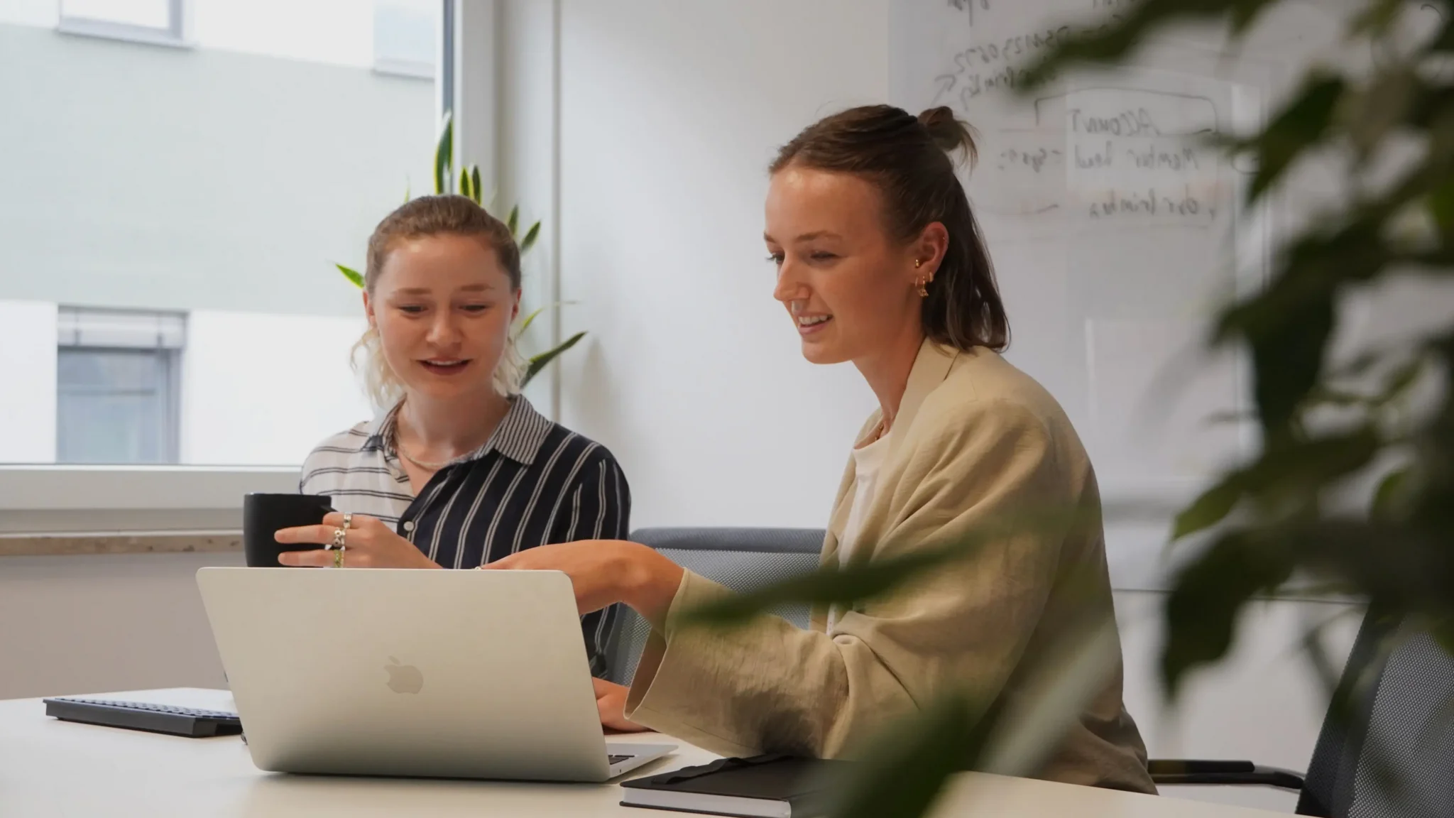Beratungstermin vereinbaren Zwei Frauen sitzen am Tisch und schauen beiden auf den Laptop vor sich