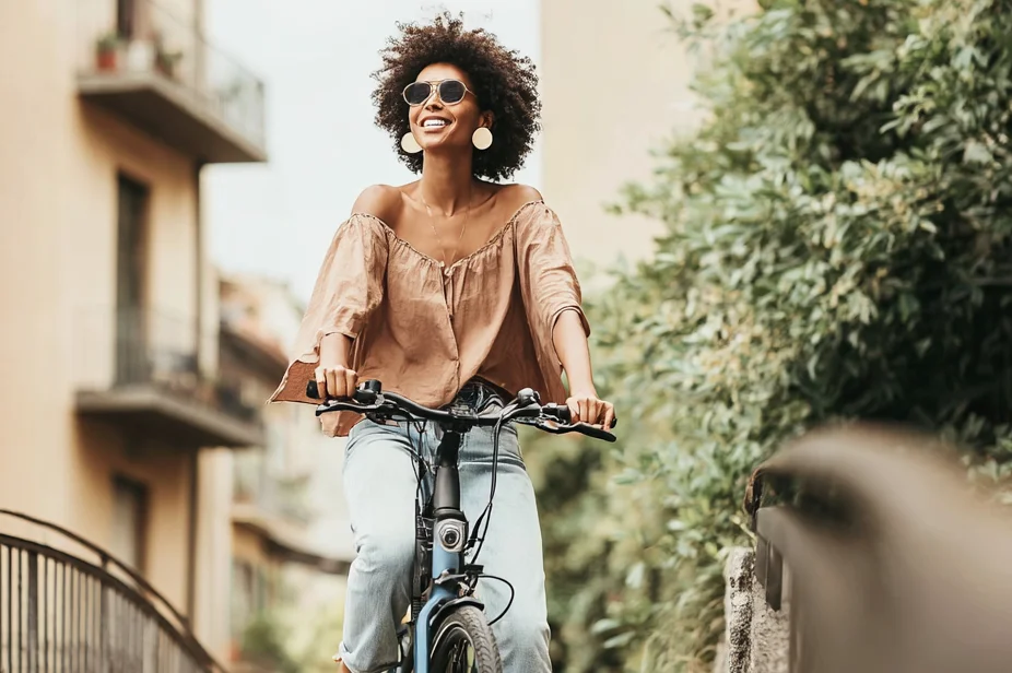 Frau mit Sonnenbrille fährt Fahrrad 